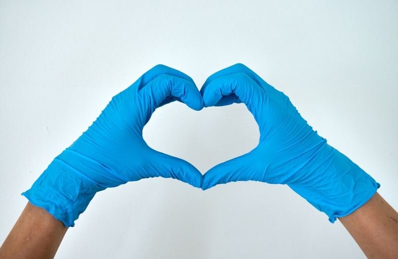 Gloved hands forming a heart shape